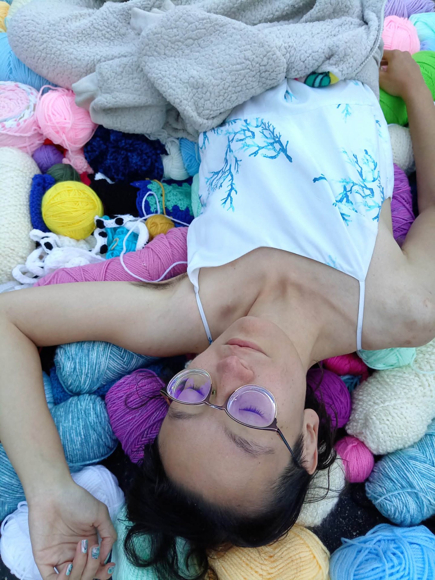 Muchtar resting among colorful skeins of yarn