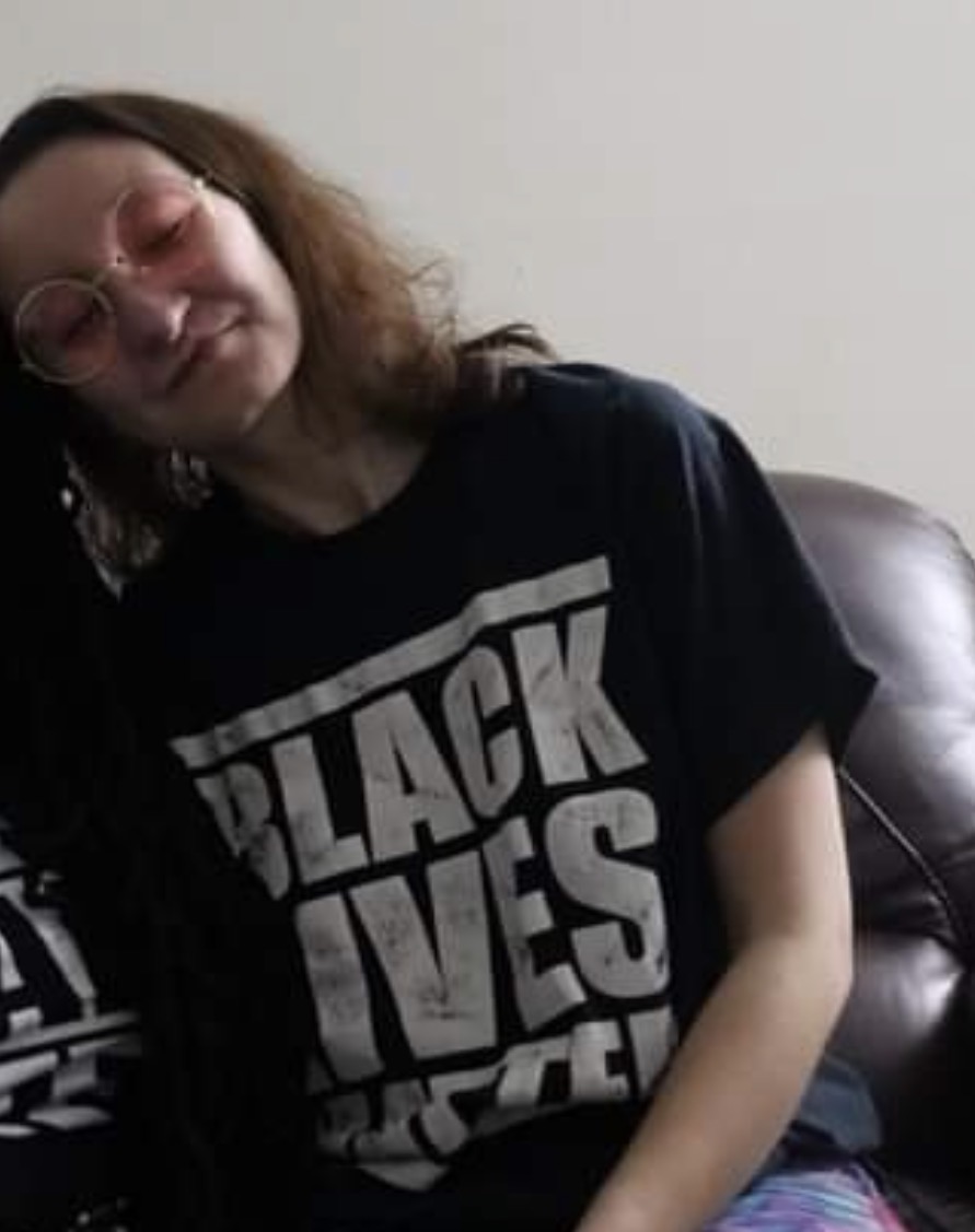Muchtar resting on a couch in a Black Lives Matter shirt